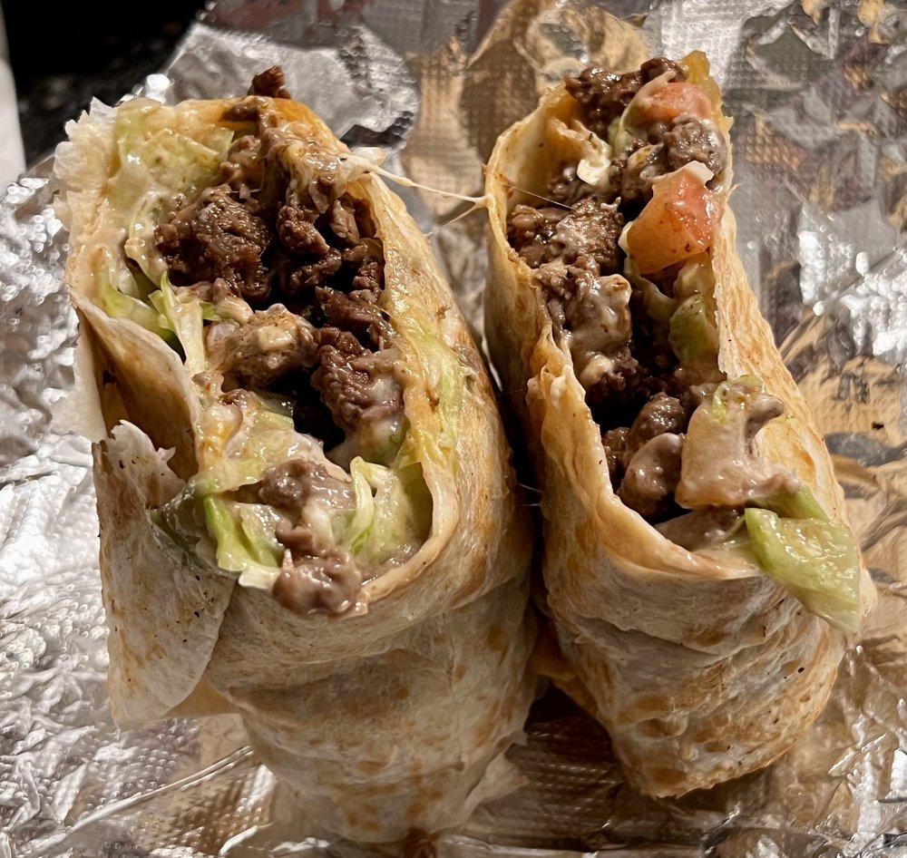 Asada burrito cut open, packed with grilled steak and melted cheese
